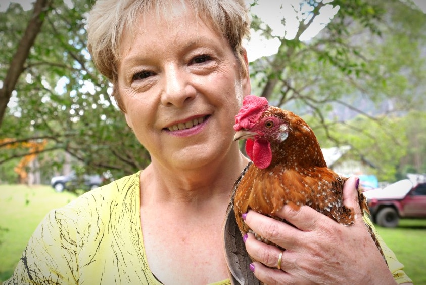 A woman holds a chicken