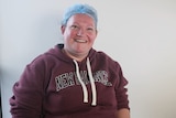 A woman wearing hair net smiles at the camera.