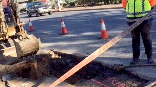 Workmen and equipment at the burst water main.