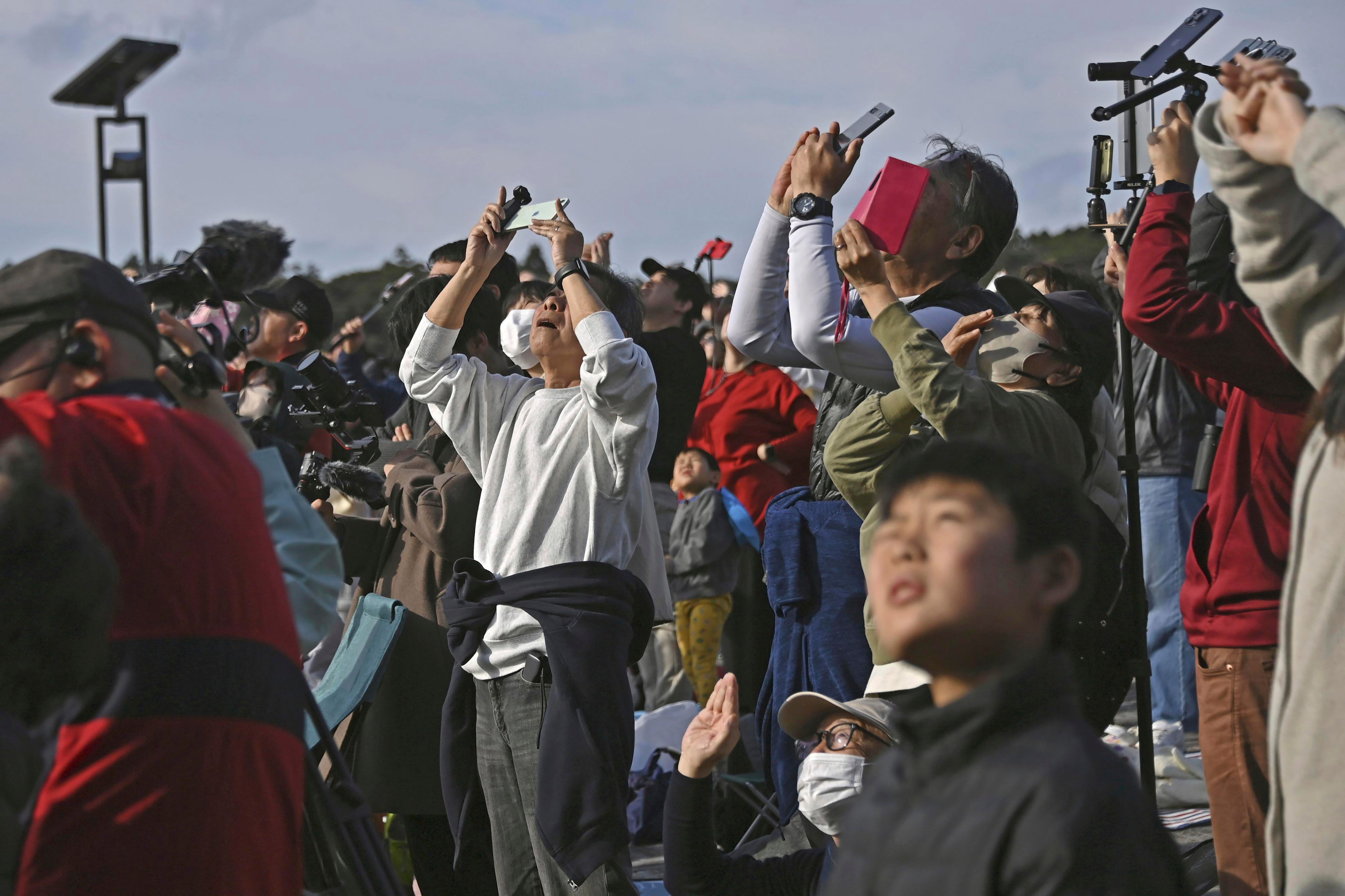 People in Minamitane town, Kagoshima, southern Japan, watch as an H3 rocket lifts off.