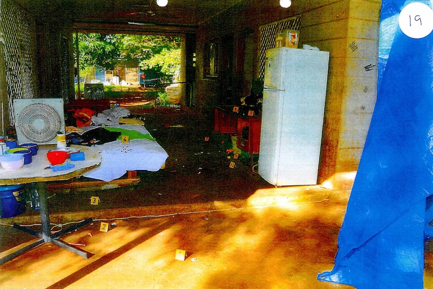 An room open to the outside on either end, showing evidence tags on lots of items.