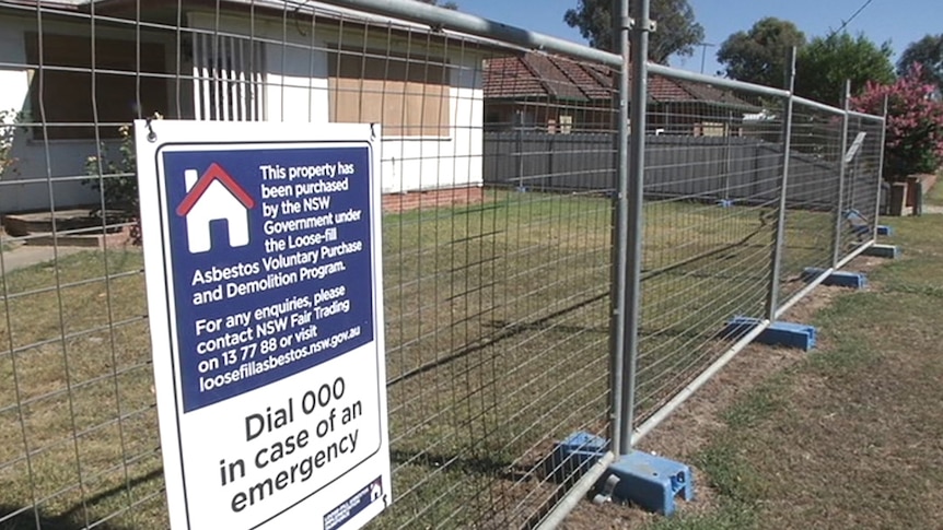Asbestos sign in front of house in Holbrook.