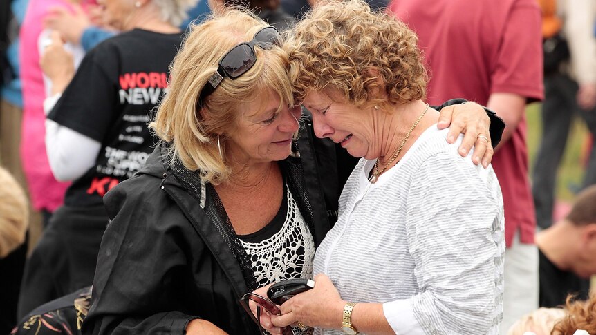 Family members grieve during a memorial service on the anniversary of the Christchurch earthquake.