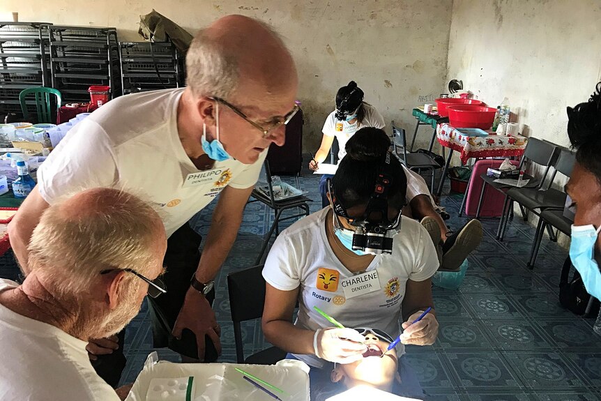 A team of dentists do a check-up on a Maubisse school student.
