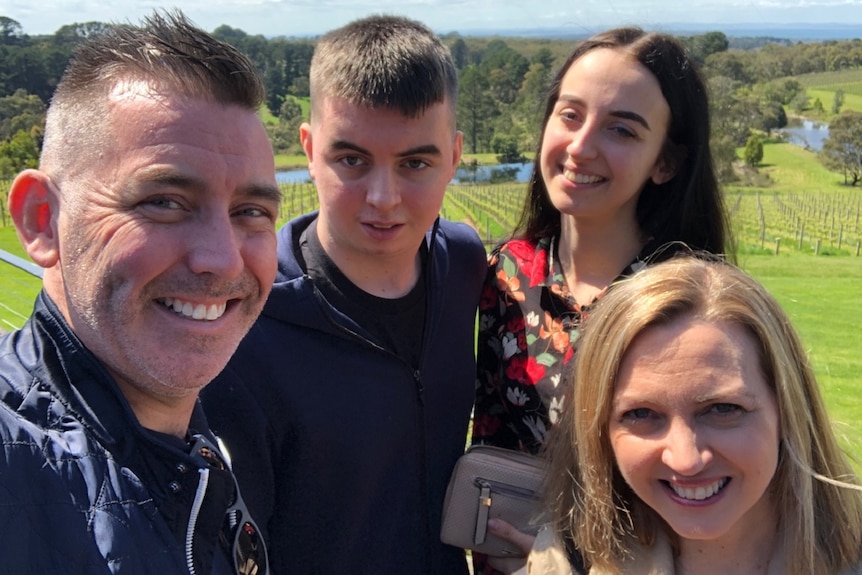 A family smiling in a selfie taken overseas