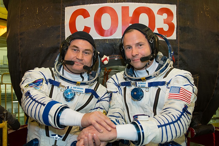 Alexey Ovchinin of Roscosmos (left) and Nick Hague of NASA (right) in front of the Soyuz MS-10 spacecraft.