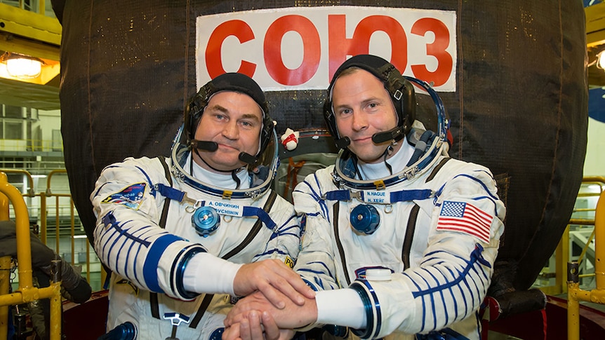 Alexey Ovchinin of Roscosmos (left) and Nick Hague of NASA (right) in front of the Soyuz MS-10 spacecraft.