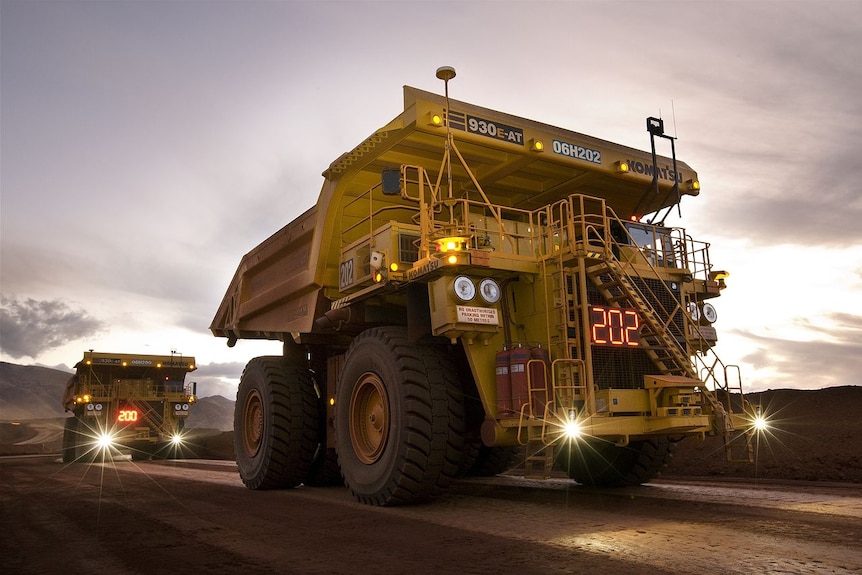 Mining dump trucks driving along a dirt truck