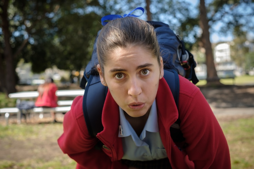 A still from Stan series Bump with a teenage girl in school uniform doubled over in pain