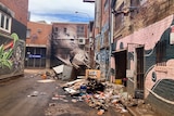 A street with flood damaged goods and a mural