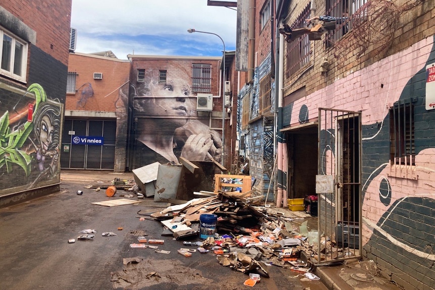 A street with flood damaged goods and a mural