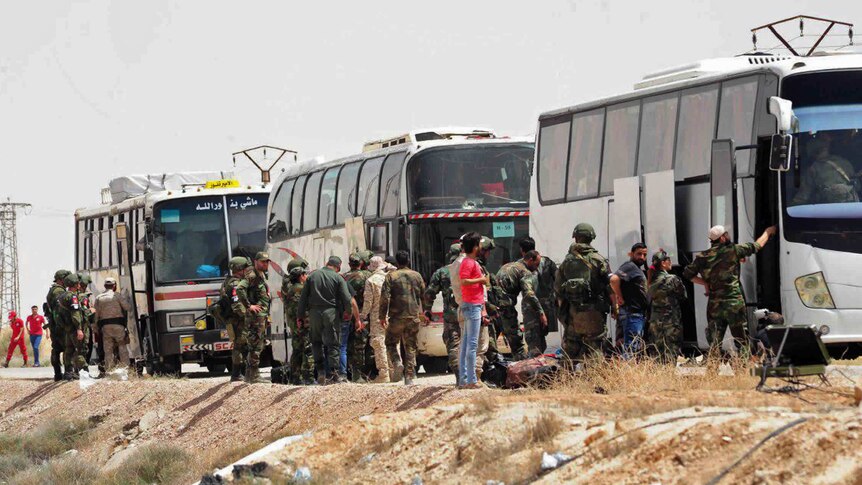 People lining up to board buses.