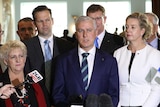 Nationals watch leader Michael McCormack during a press conference. They all have blank expressions on their faces.