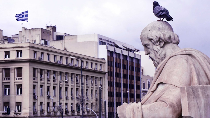 A pigeon sits on top of a statue of Plato in modern day Athens.