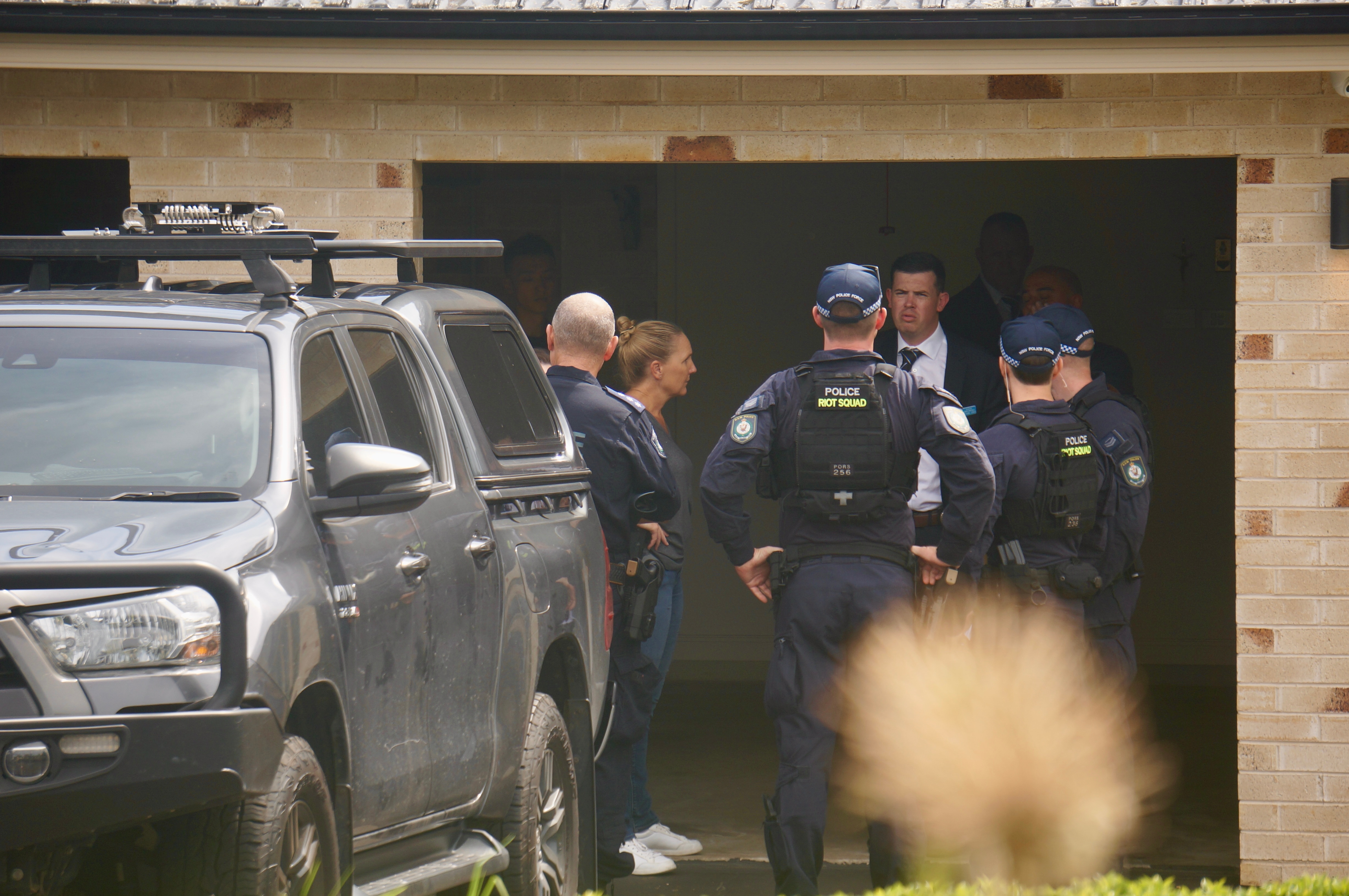 Police officers outside a house.