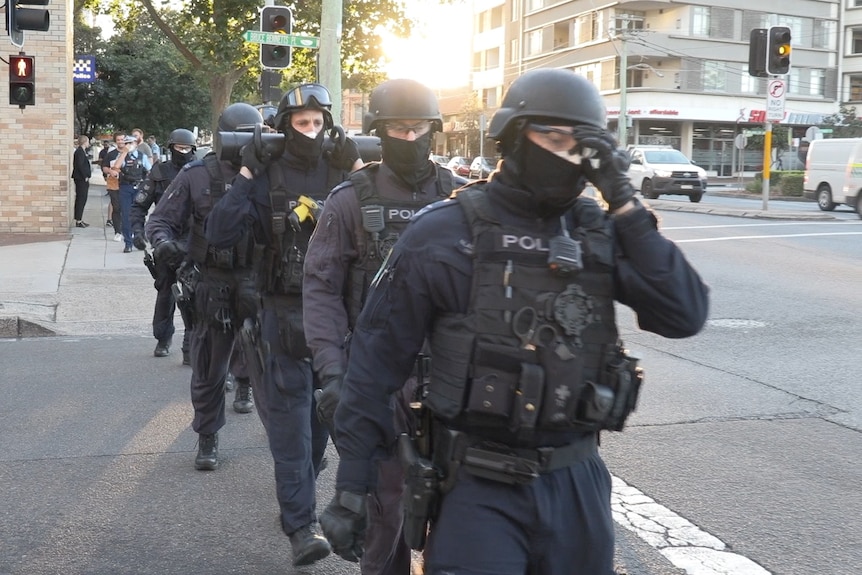 tactical police walking down a road