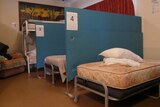 two empty beds separated by a blue partition