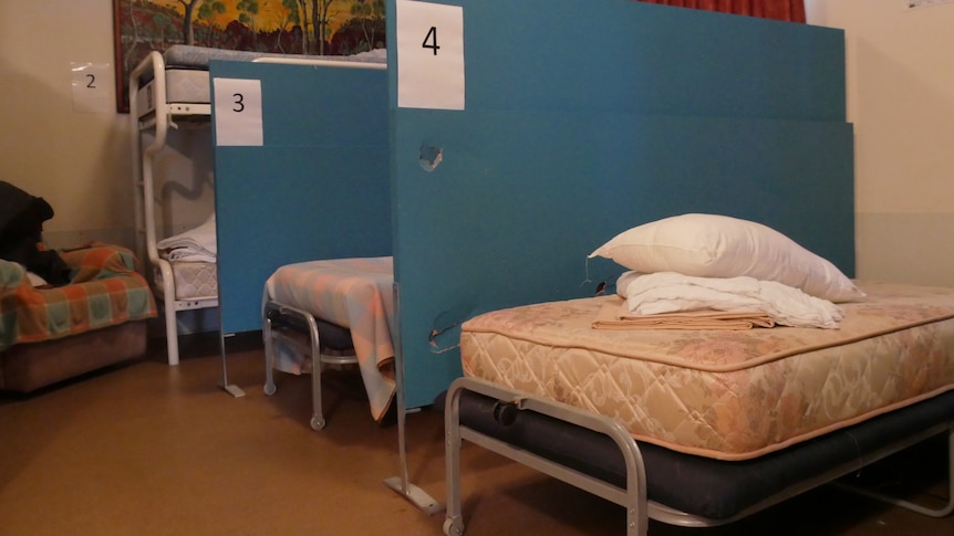 two empty beds separated by a blue partition
