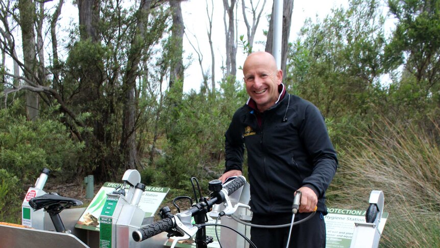 A photo of Gary Muir using the wash-down station to clean his bike.