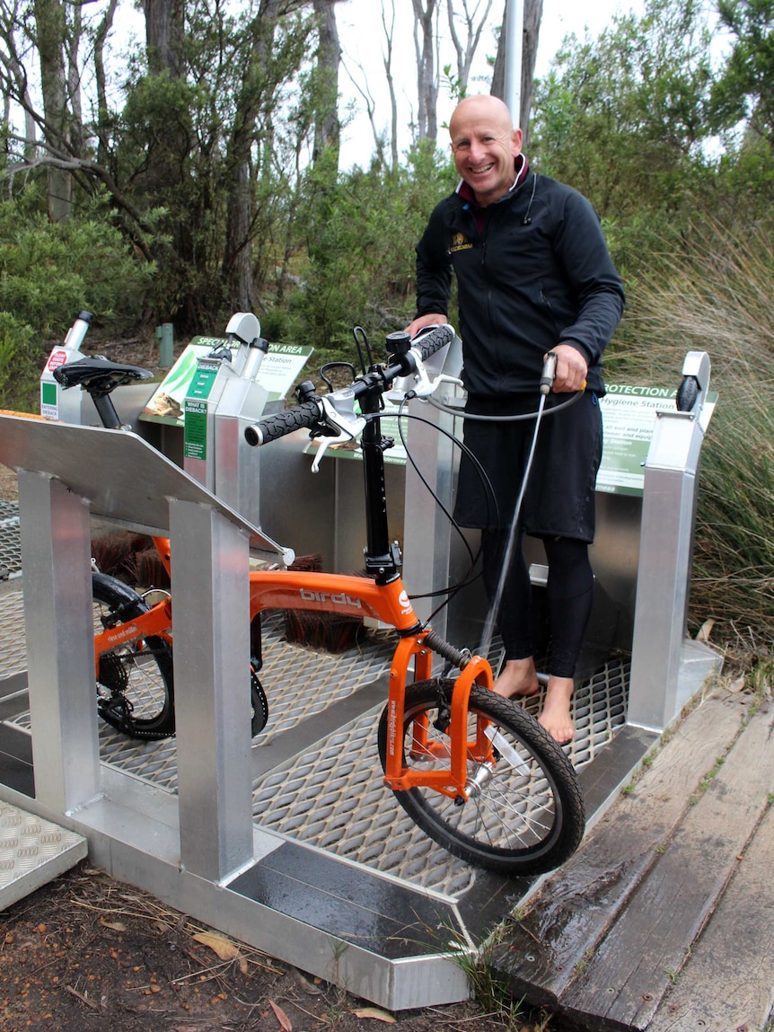 A photo of Gary Muir using the wash-down station to clean his bike.