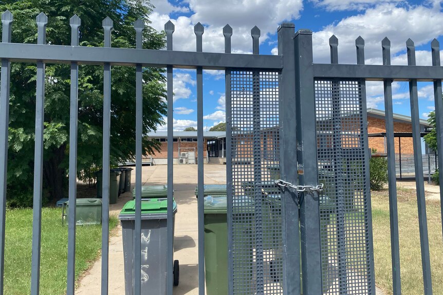A padlocked gate outside a school.