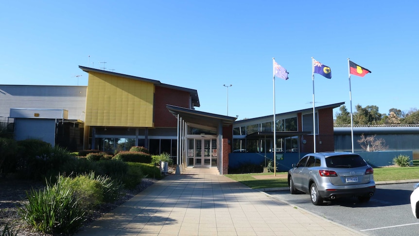 The front of the Banksia Hill Detention Centre with the Australian, West Australian and Indigenous flags flying.