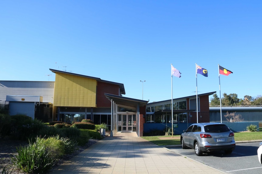 The front of the Banksia Hill Detention Centre with the Australian, West Australian and Indigenous flags flying.