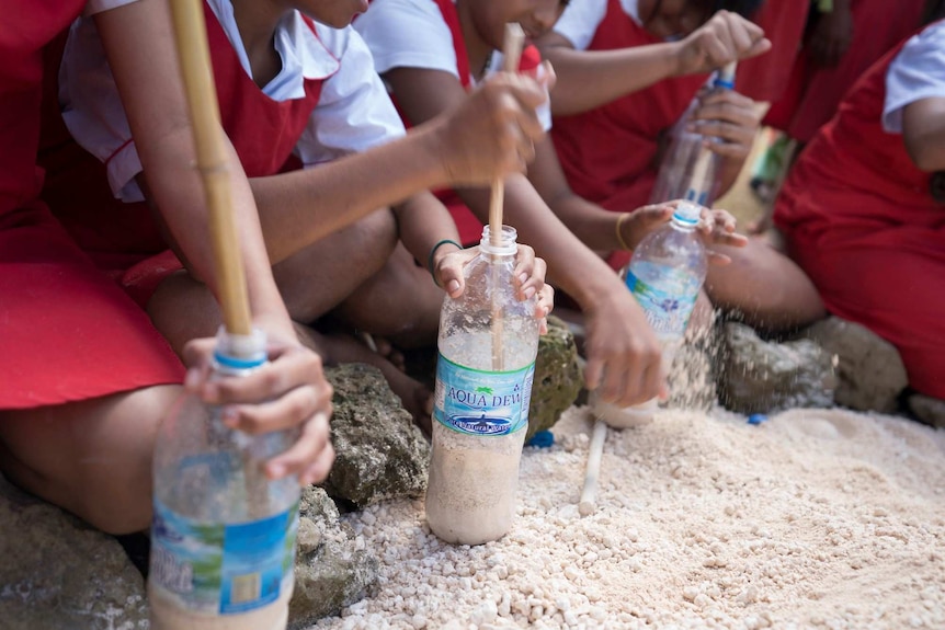 Kids fill bottles for Phil Smith's Tonga bottle house