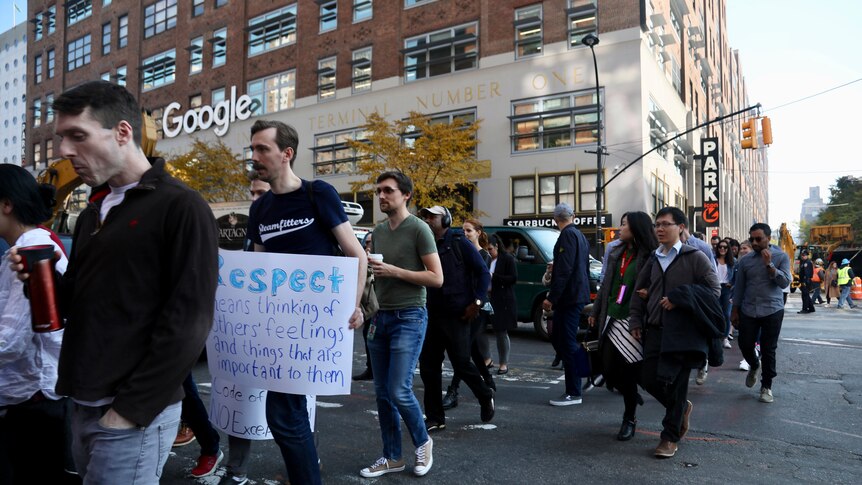 Dozens of Google employees walk in the streets holding signs