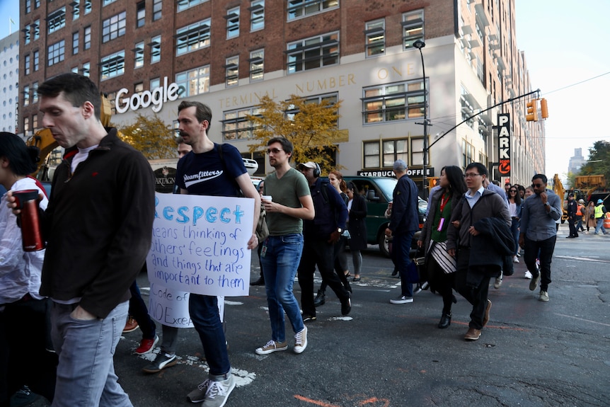 Dozens of Google employees walk in the streets holding signs