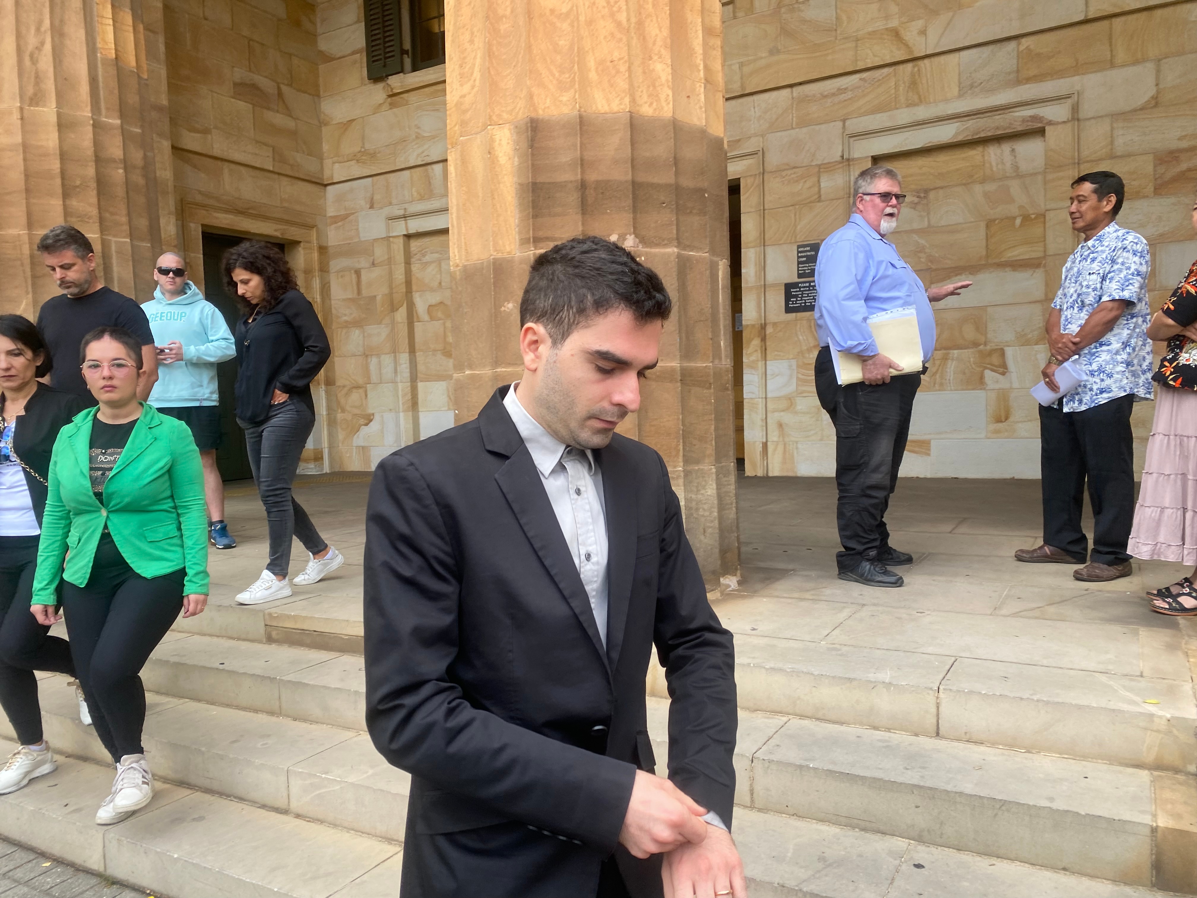 a man in a business suit walks outside a court building