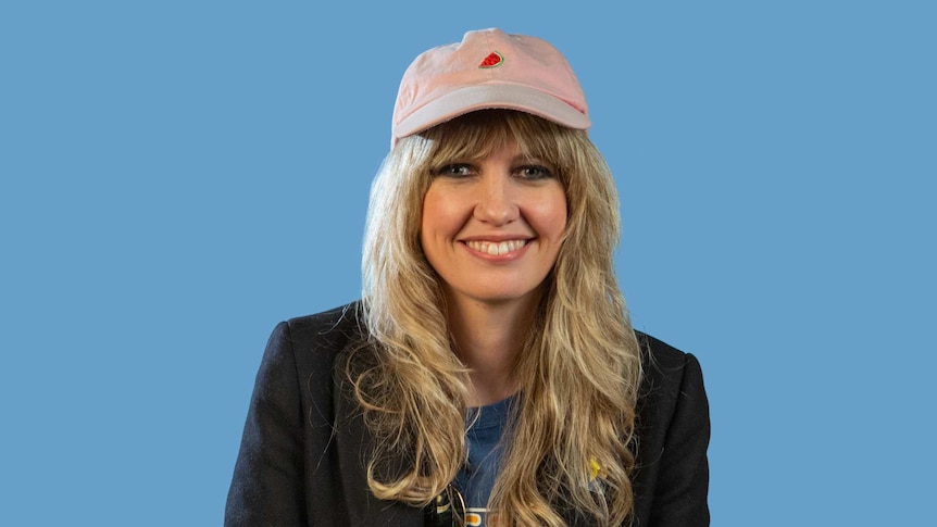 Ladyhawke smiling in front of a blue background, still from triple j's Inspired video