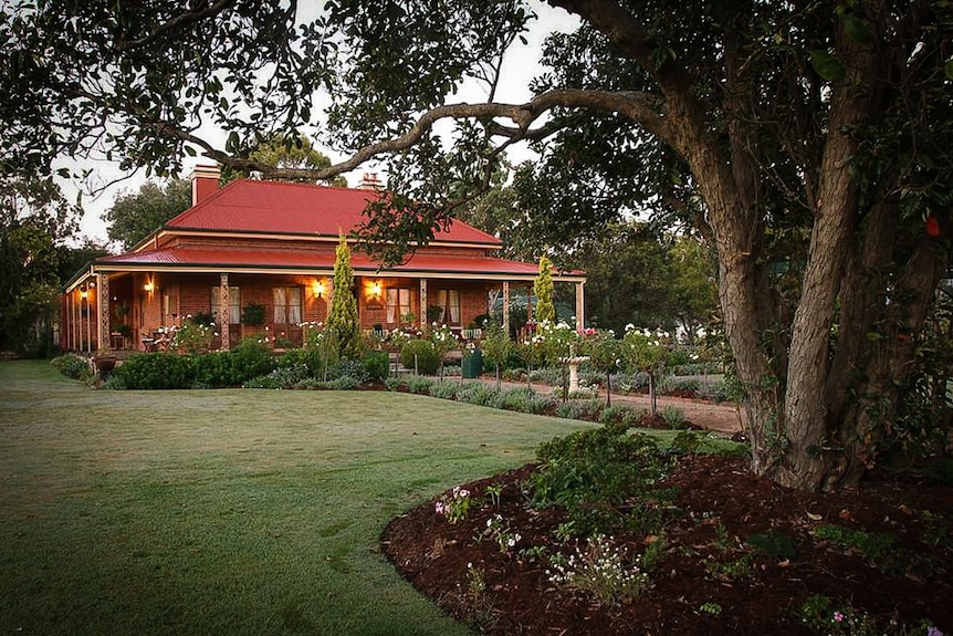 Brick house exterior with rose garden in foreground.