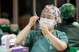 A nurse pulls up a syringe of COVID-19 vaccine.