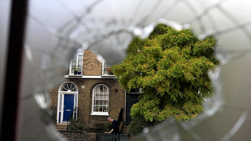 A man returns to his home in Hackney during riots