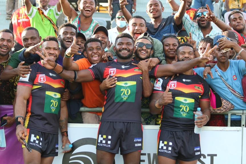 PNG hunters players embraced by crowd on field 
