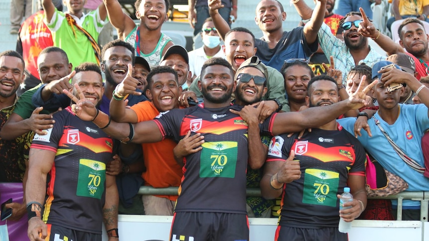 PNG hunters players embraced by crowd on field 