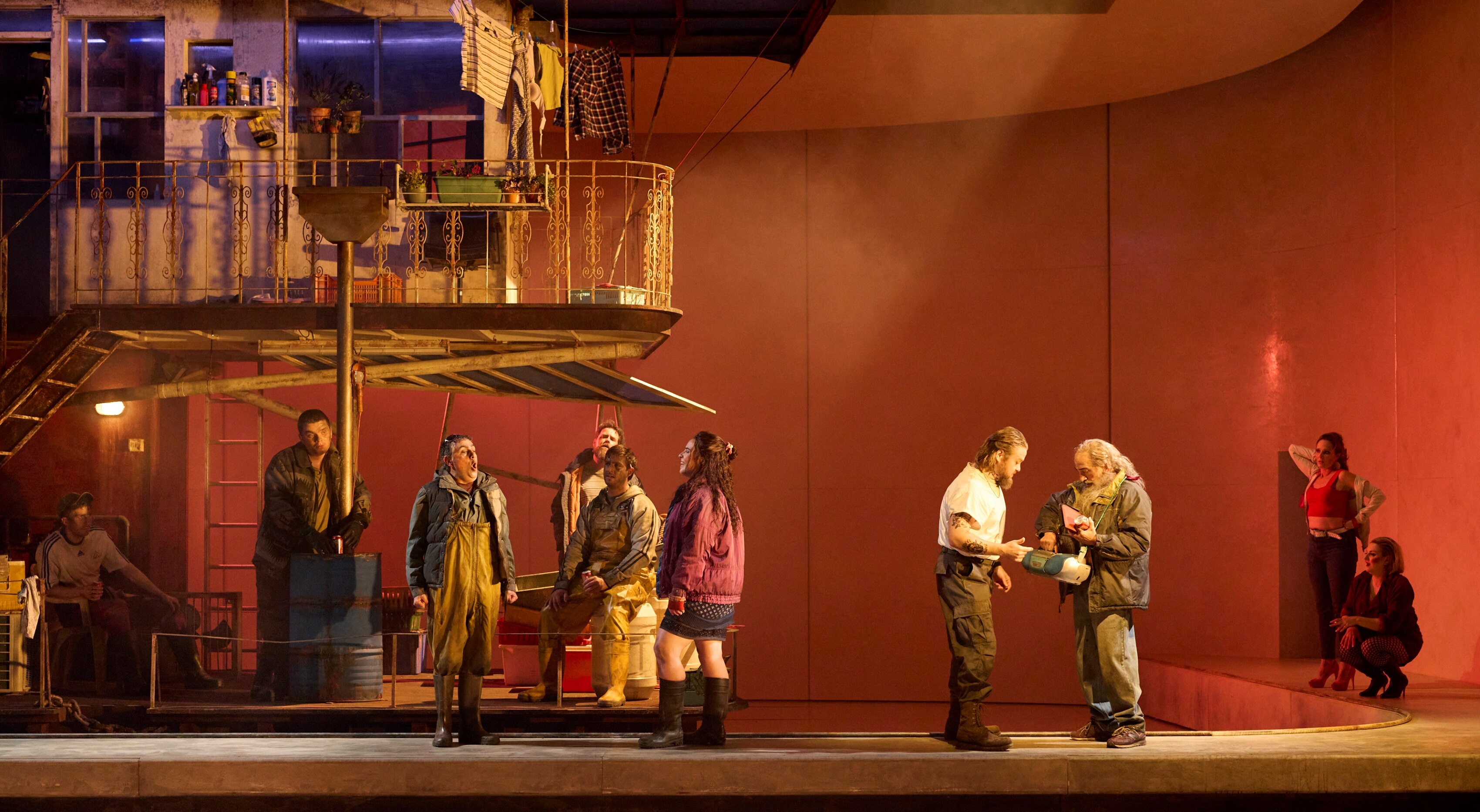 A man and a woman stand next to a pole, the man holds his hand to the woman's face