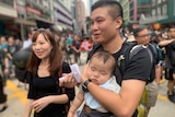 A mother, father and baby attend a protest on the streets of Hong Kong on 16 June 2019.