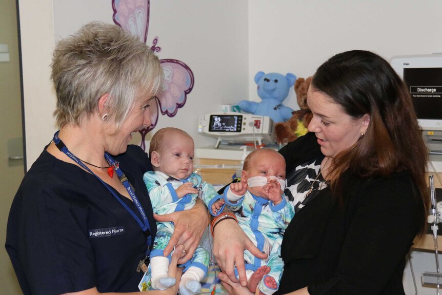 Premature twins Lachlan and Xavier Pead with a nurse and mother Erin Hill in Hobart.