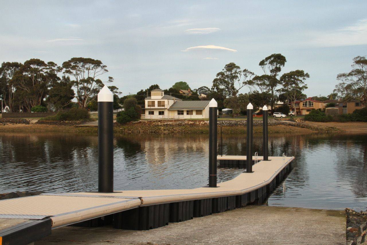 Uma rampa para barcos se estende sobre um lago.