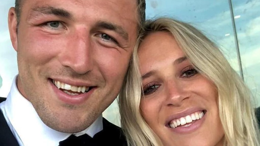 A close up selfie of a man in a suit with a smiling blond woman.