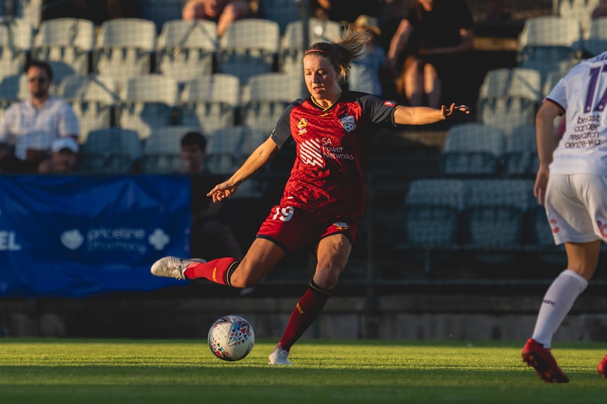 Maruschka Waldus kicks a soccer ball.