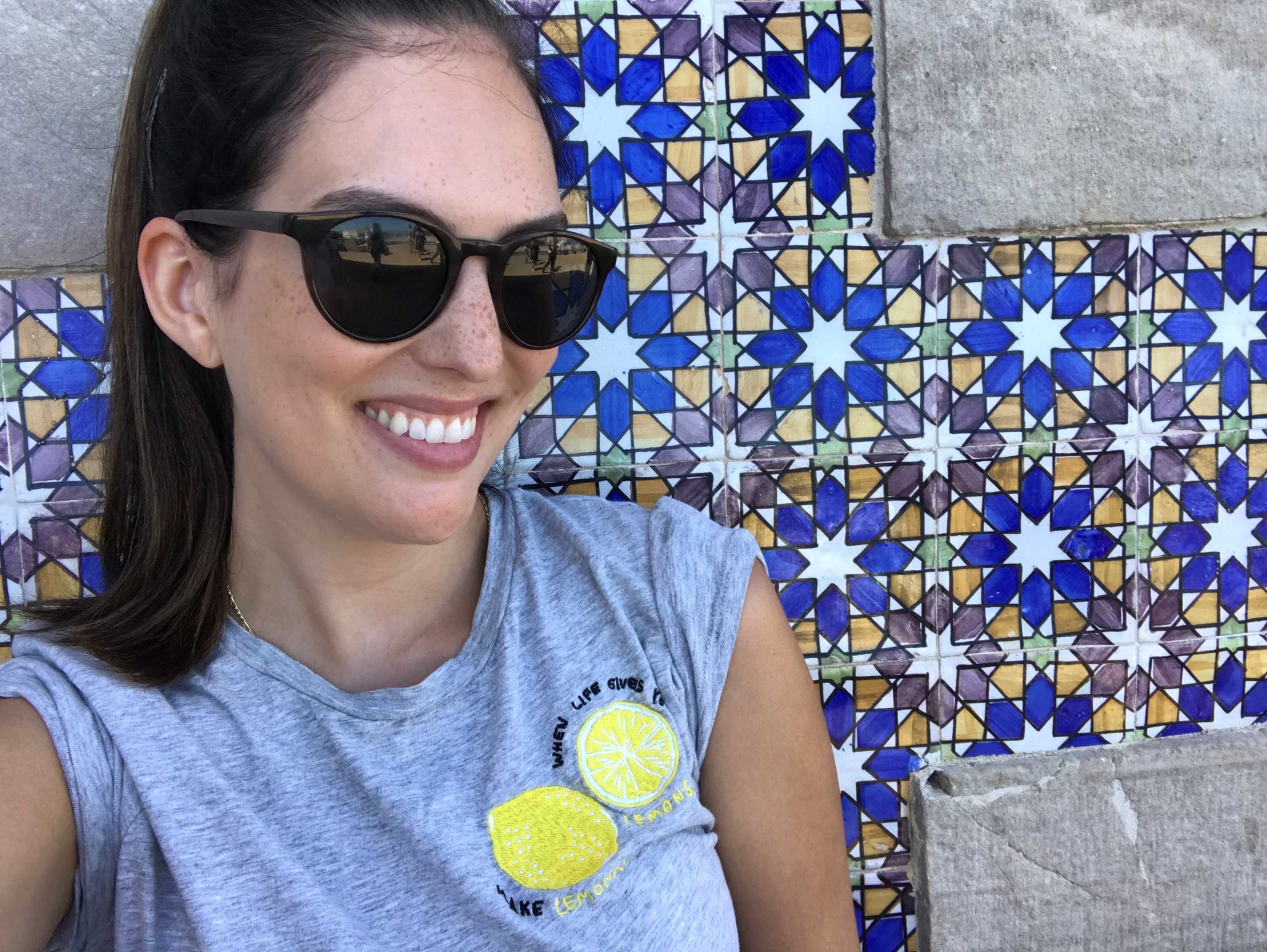 Skincare fan Chantelle Peterson wearing dark black sunglasses and smiling.