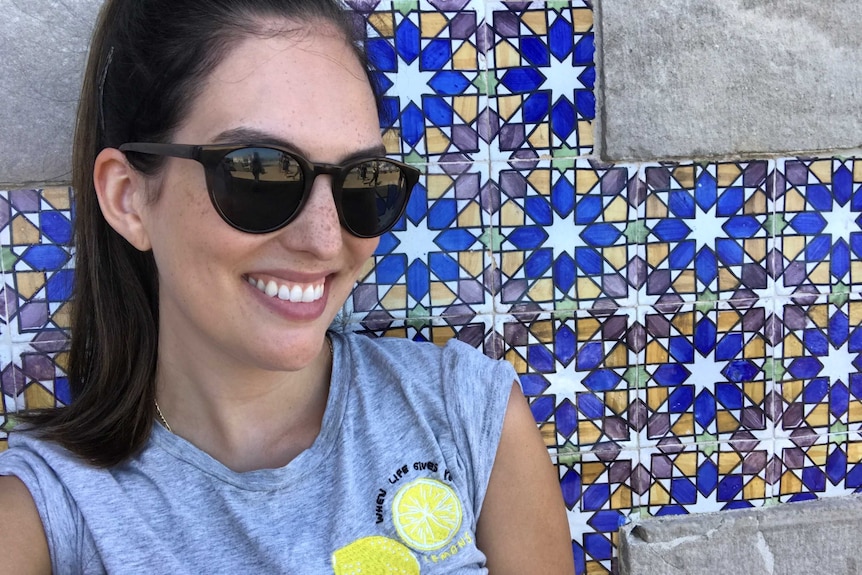 Skincare fan Chantelle Peterson wearing dark black sunglasses and smiling.