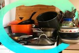 A pile of dirty pots, pans and bowls needing to be washed up, mess created by not meal planning.