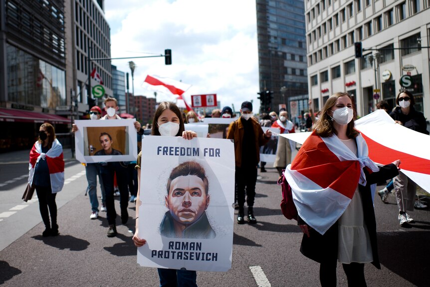 A woman holds a poster with the image of Belarus opposition activist Roman Protasevich during a demonstration