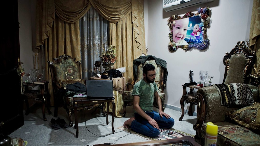 Leader: Anas performs evening prayers in an occupied apartment near the Salahudeen district of Aleppo