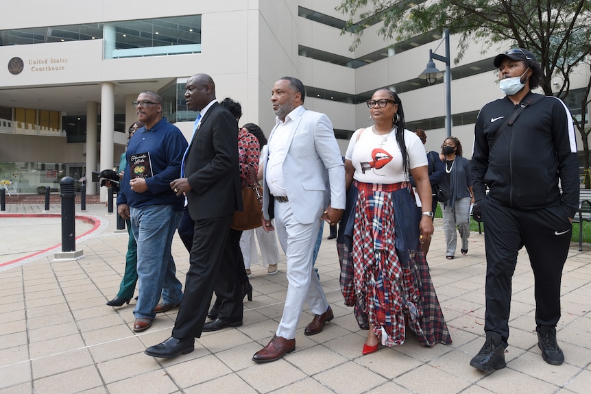 A group of five people leaving a court building. 