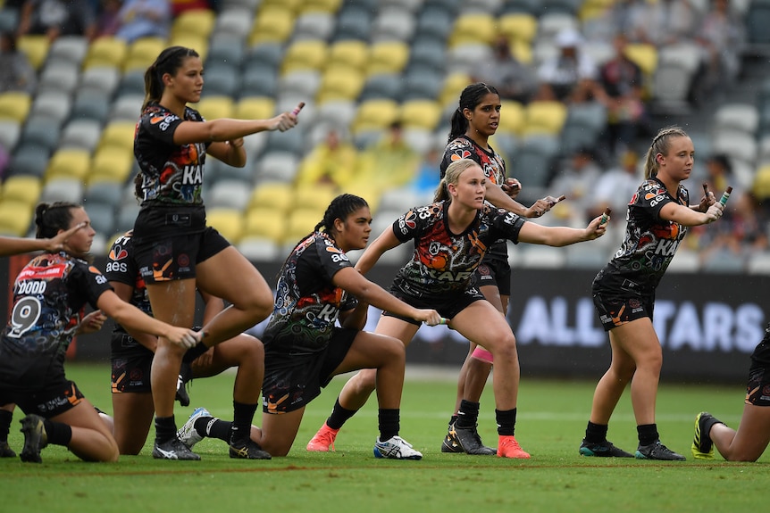 A group of Indigenous women perform a 'war cry' ahead of a rugby league match.